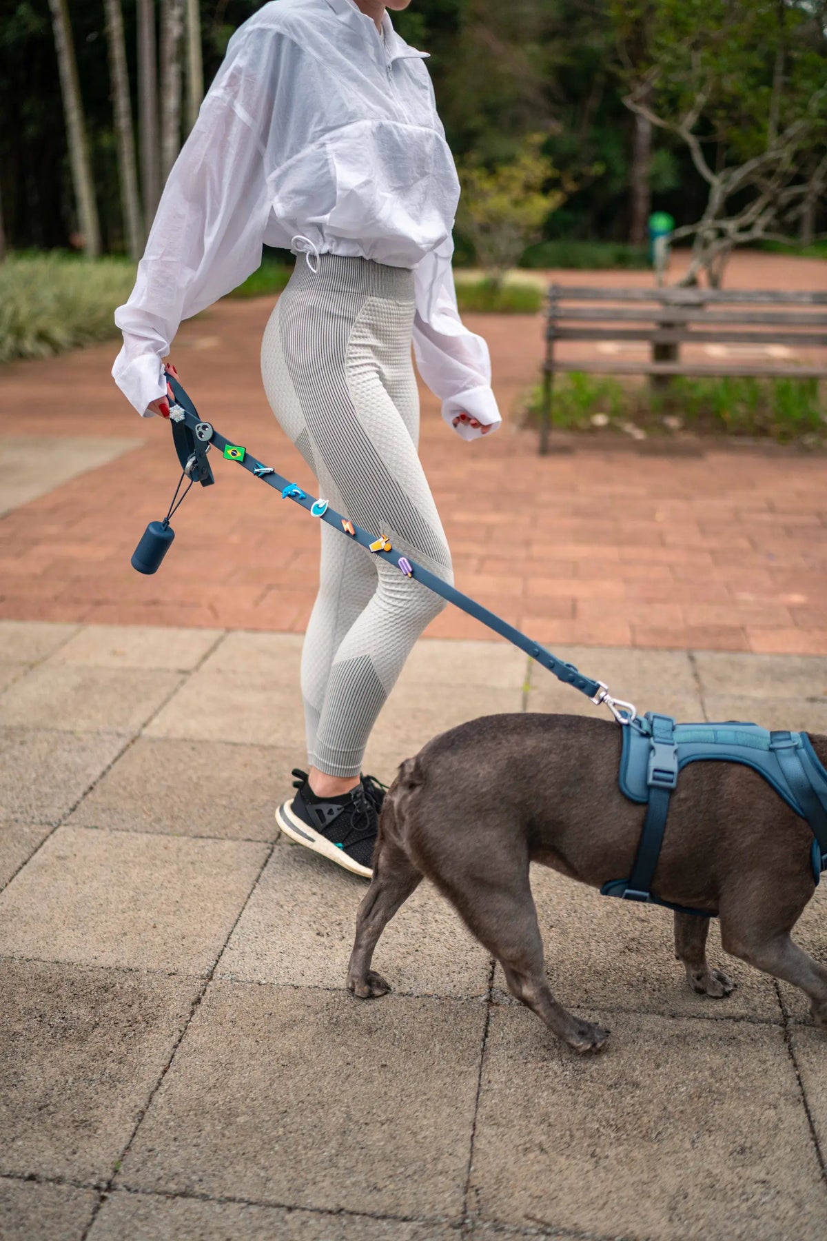 Tutora passeando na rua com o cachorro usando o kit Patta Navy